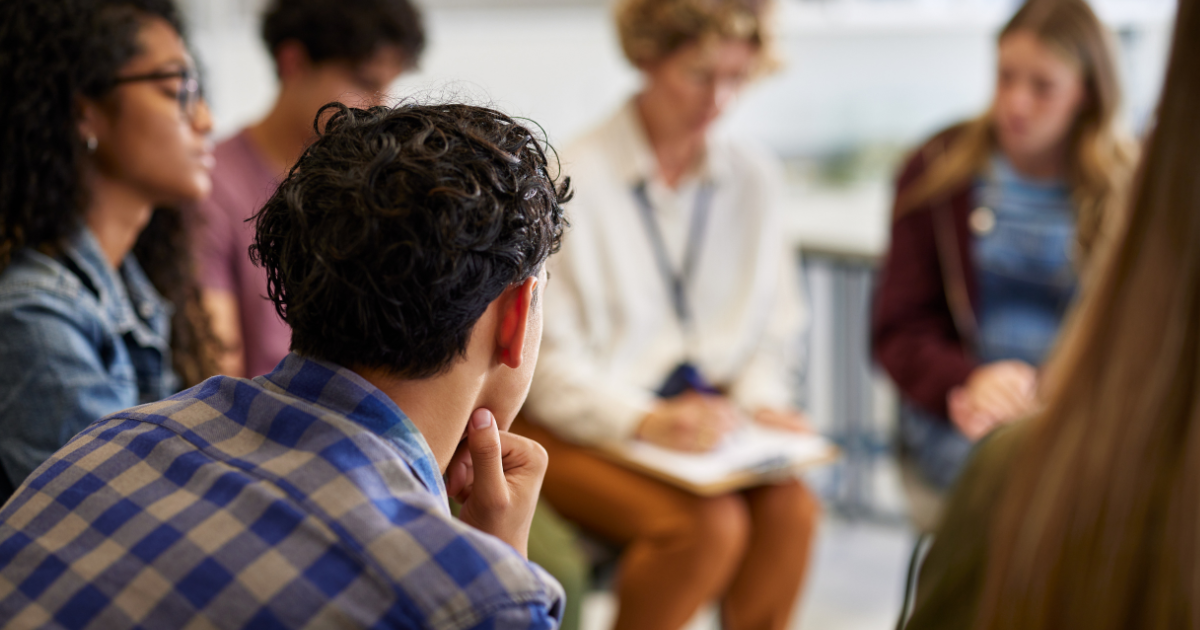 People gathered in a small group, listening and reflecting together, showing support around New Year’s resolutions in addiction recovery.
