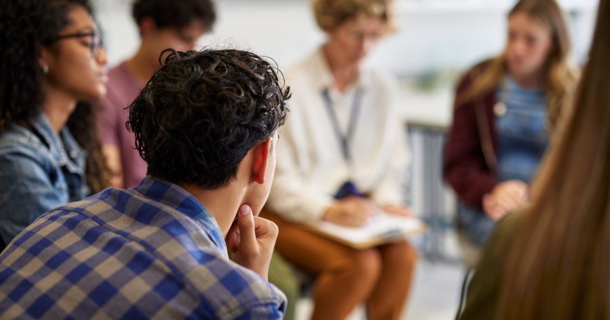 Addiction counselor leading a group therapy session, helping individuals in recovery build coping skills and support networks.