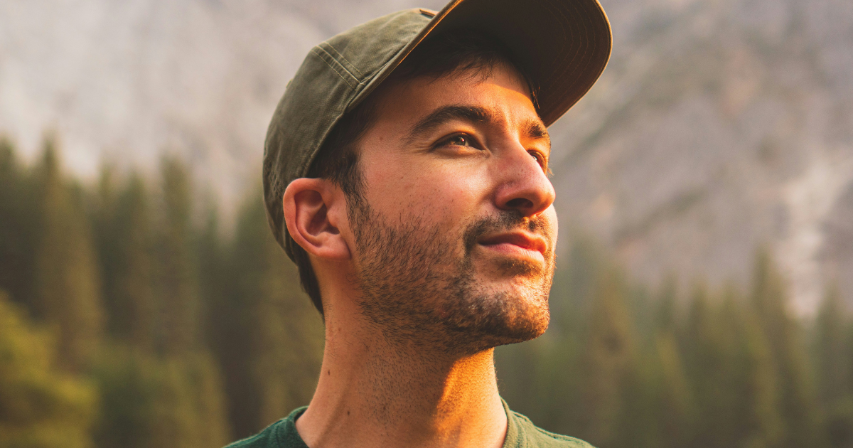 Man standing outdoors looking ahead thoughtfully, representing planning ahead for holidays in recovery, self-reflection and preparing for celebrations while protecting well-being.
