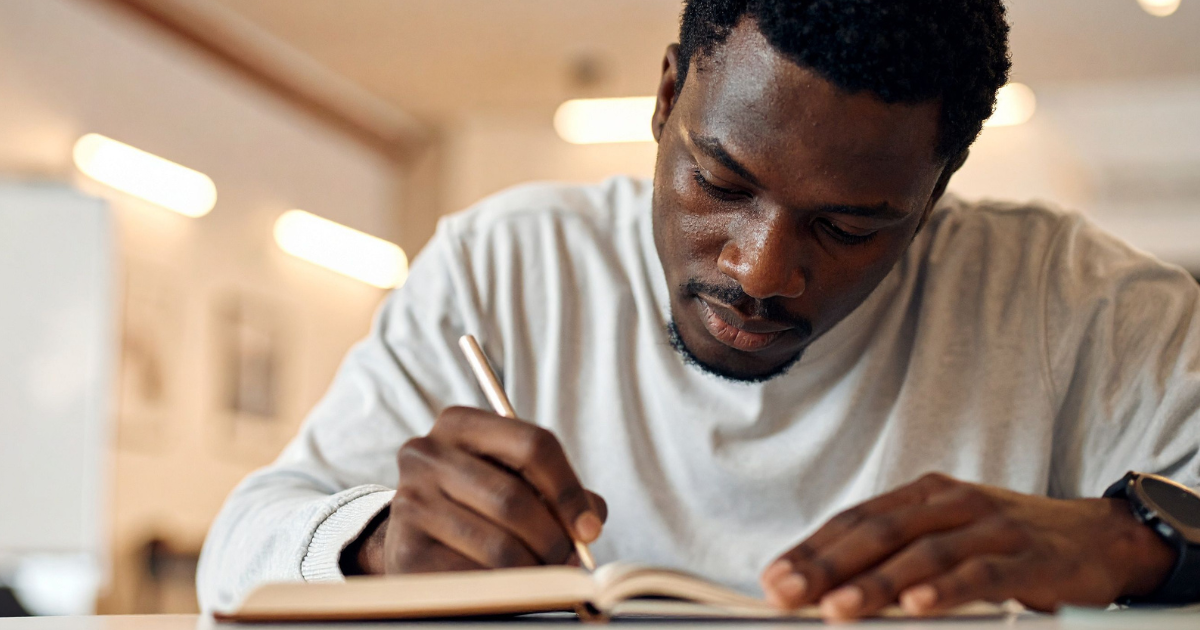 Person writing in a notebook as part of a recovery plan, representing coping skills in recovery, relapse prevention planning and preparing for holidays and celebrations.