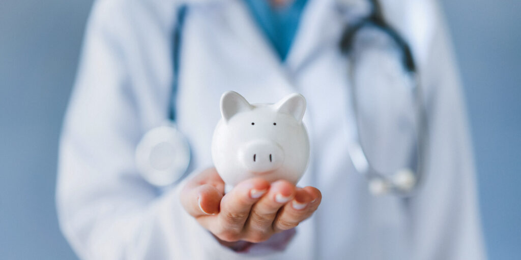 Doctor holding white piggy bank, symbolizing Medicare savings for addiction recovery treatment.