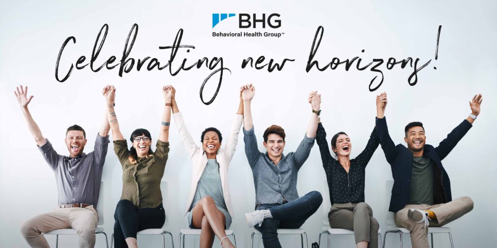 Diverse group of smiling people sitting with raised arms celebrating BHG's acquisition of CBH.