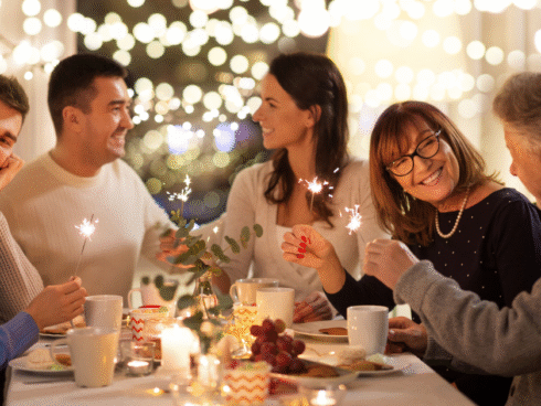 Group of people, smiling around a holiday table.