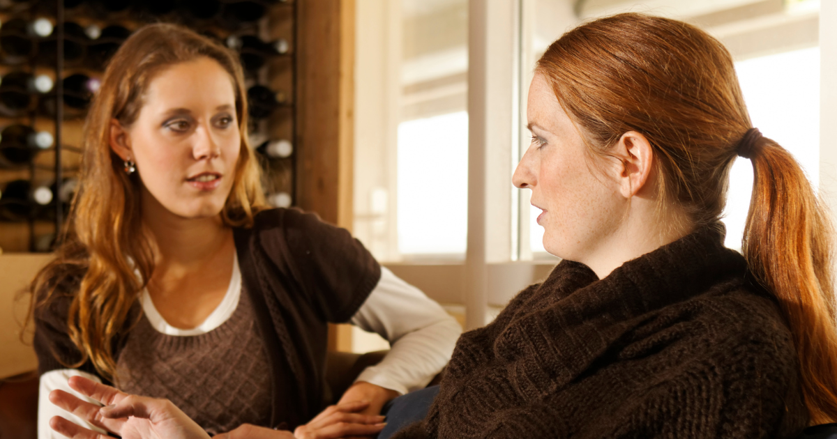 Two women engaged in a supportive conversation, discussing recovery goals and planning responses for social situations during the holiday season.