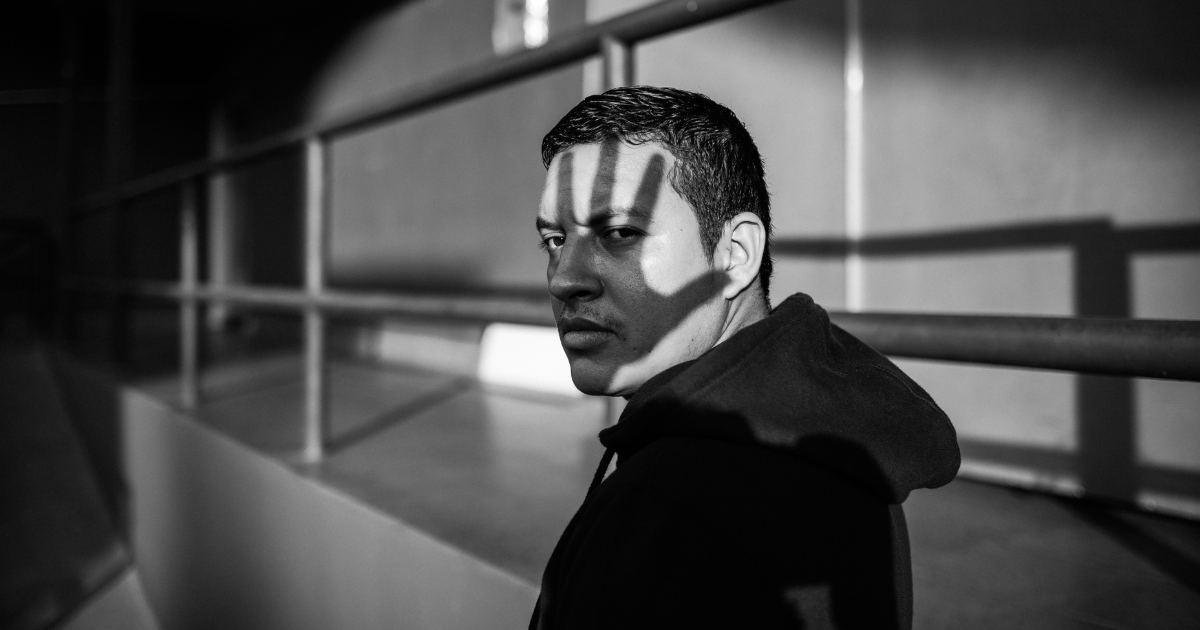 A person standing in a dimly lit area, symbolizing the stigma and challenges faced by people with opioid use disorder (OUD).