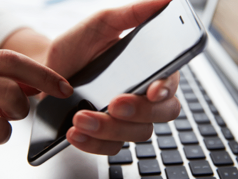 An individual on their phone doing telehealth, symbolizing the flexibility of technology in addiction treatment and recovery.