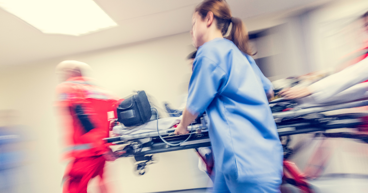 Medical professionals rush a patient on a stretcher through a hospital hallway, representing the urgency and risk of overdose without proper treatment.
