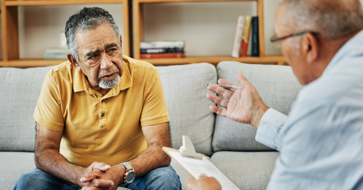 A man sits with a healthcare provider, discussing treatment options, symbolizing support, trust and the next step toward recovery.