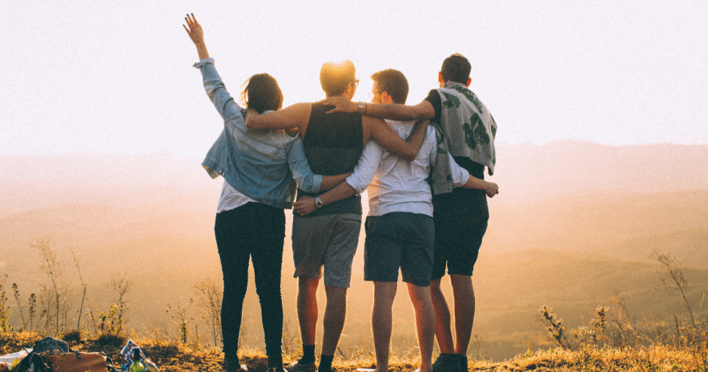 Group of friends gathered together in a friendly hug, symbolizing support and togetherness for addiction recovery during Recovery Month.
