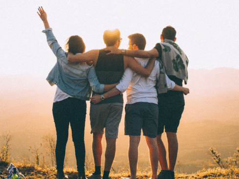 Group of friends gathered together in a friendly hug, symbolizing support and togetherness for addiction recovery during Recovery Month.