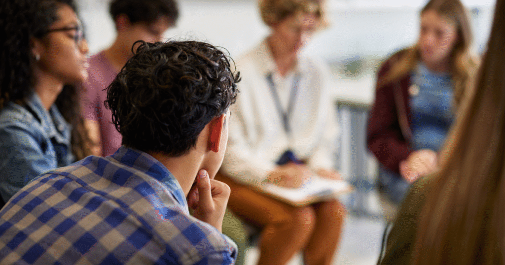 Addiction counselor leading a group therapy session, helping individuals in recovery build coping skills and support networks.