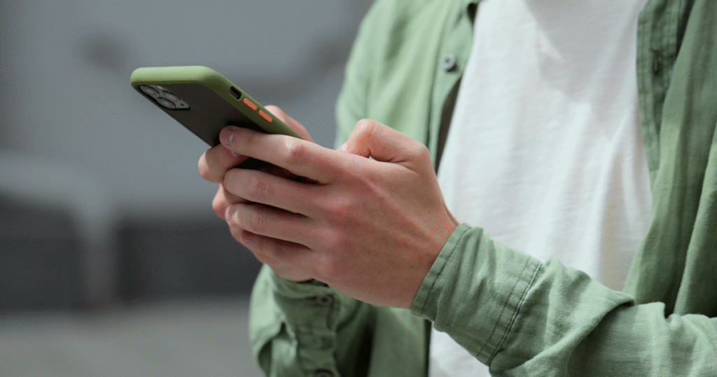 Man on his phone, symbolizing the start of reaching out to talk to a professional about changes in insurance for treatment and recovery.