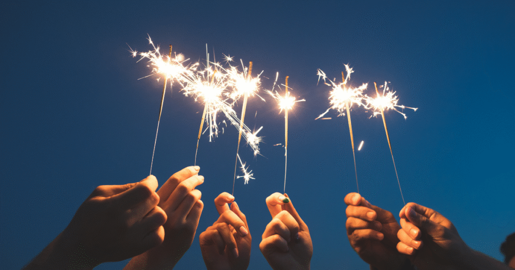 An image of a group of people with fireworks in their hands celebrating the new year.