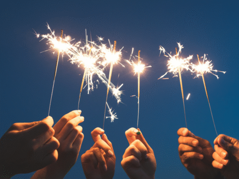 An image of a group of people with fireworks in their hands celebrating the new year.