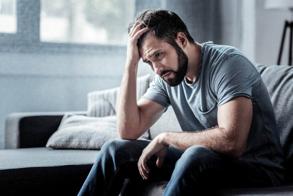 Man experiencing stress and discomfort related to kratom withdrawal symptoms.