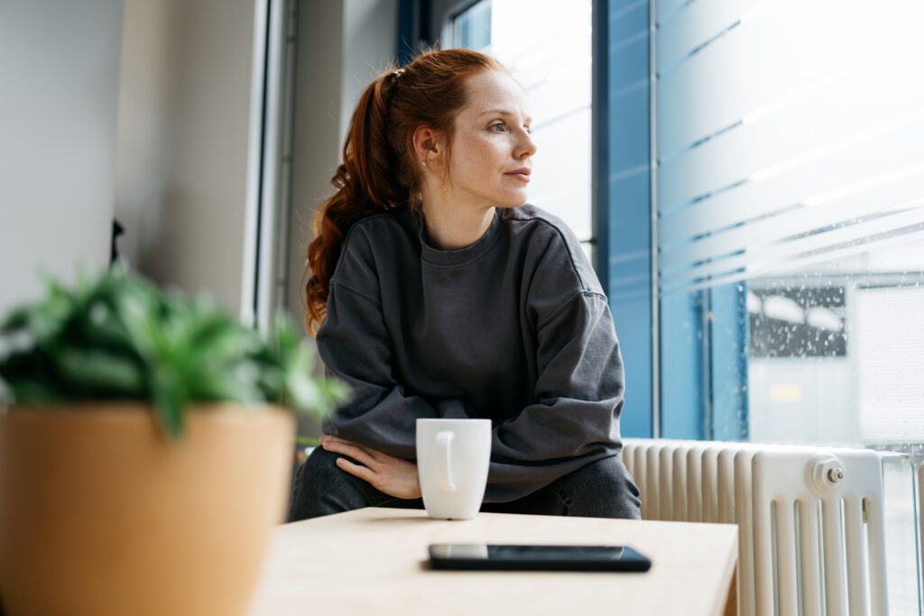 Woman reflecting during recovery from kratom withdrawal symptoms.